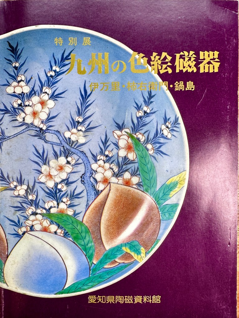 一本展覽冊,封面展示了九州特產的色彩豐富的陶瓷藝術品,背景為紫色,中央有植物和花朵的插圖,並標示展覽名稱。