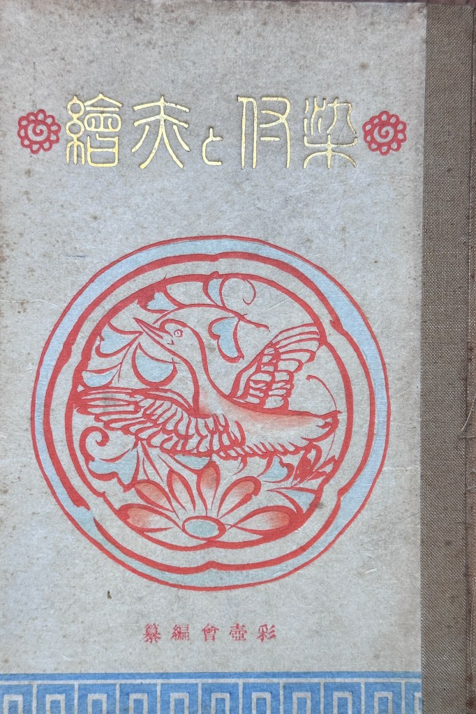 一本封面設計獨特的書籍，封面上印有紅色的花鳥圖案，標題為「戀愛與月亮」，背景為淺色紙張，書脊用深色布料包裹。